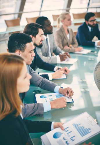 Row of business people listening to presentation at seminar